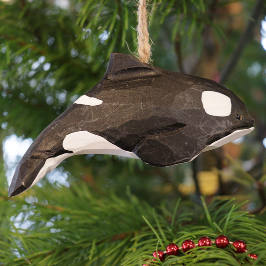 A carved orca hanging from a tree